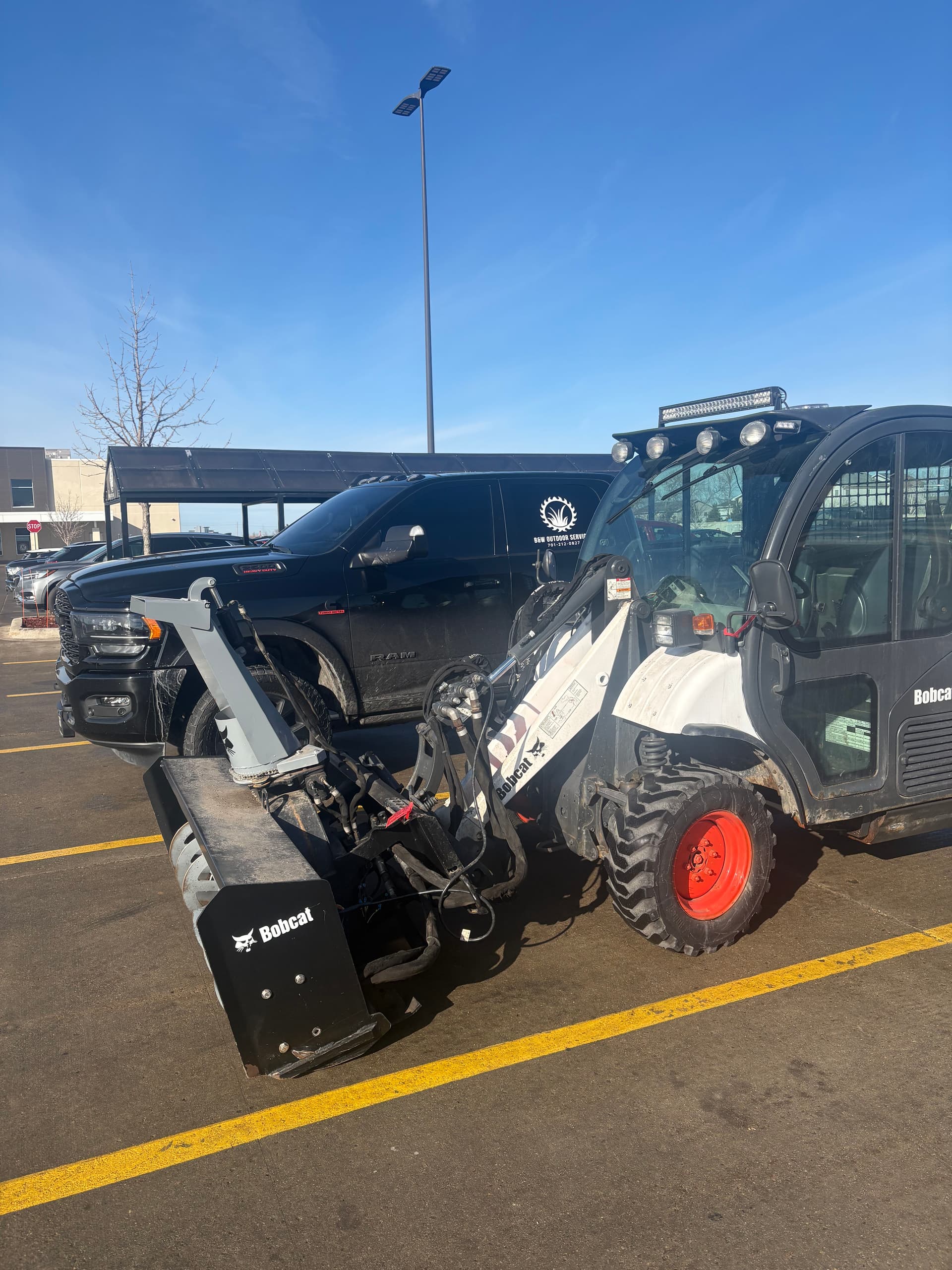 Enjoying the Weather and Prepping for Snow with Our Bobcat